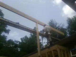 Carpenter setting a ridge beam over a new addition frame — Ice Dam Removal by Roofing Brothers in Grayslake
