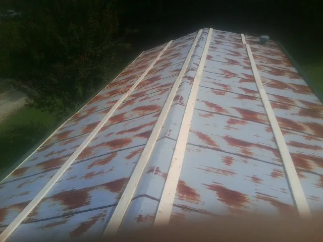Rusted metal roof panels with new wood purlins before replacement — Storm Damage Roof Repair in Grayslake by Roofing Brothers