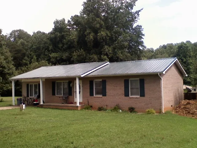 Gray metal roof on a brick ranch house with a side carport in Grayslake