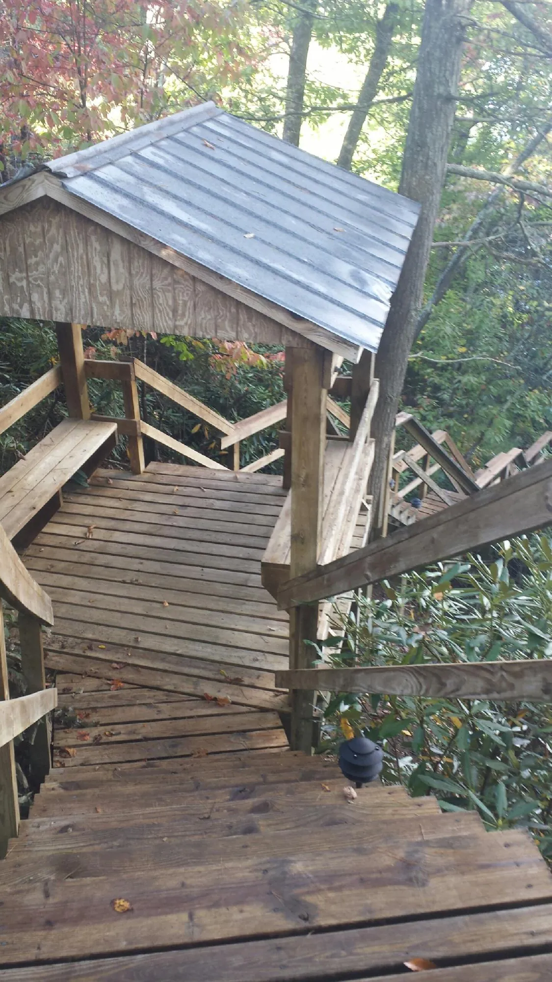 Metal roofed shelter over wooden steps on a wooded walkway — Skylight Repair & Installation work by our crew in Grayslake
