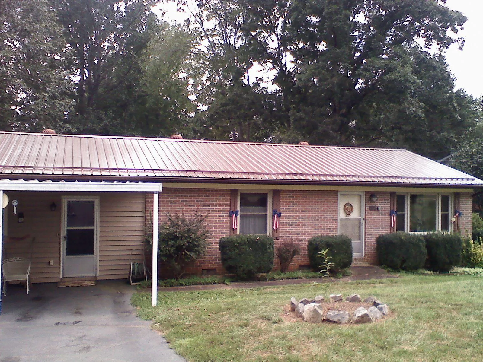 Bronze metal roof and carport on a brick ranch home — Roof Repair work by our crew in Grayslake